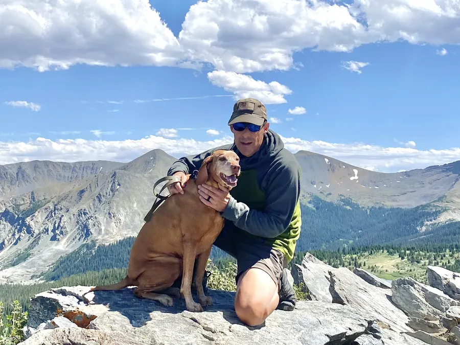 Dave Purinton with his dog on a mountain summit