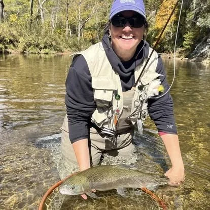 Jennifer Eggers fly fishing, holding a trout